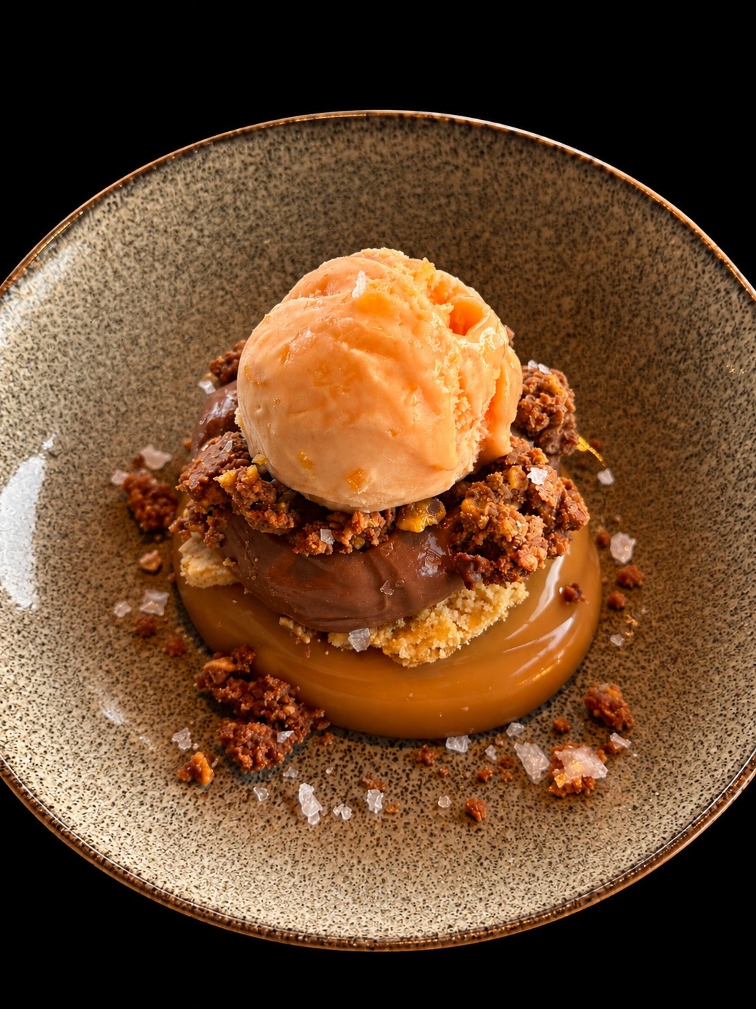 Dessert met chocolade, crumble en een bol sorbetijs