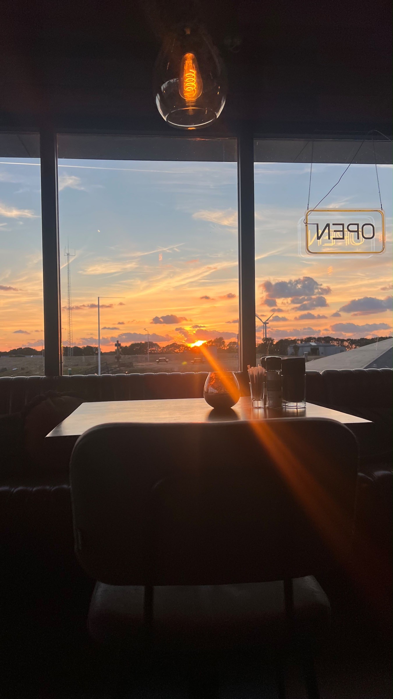Zonsondergang door het raam van het restaurant